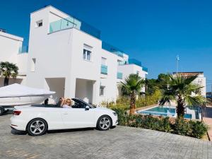 オルモス・パナギアスにあるAcrotel Porto Brava Luxury Villasの建物の前に駐車された白い車