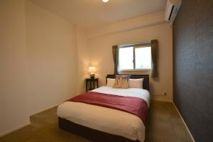a bedroom with a large bed with a window at The Grand Residence Hotel Tenjin in Fukuoka