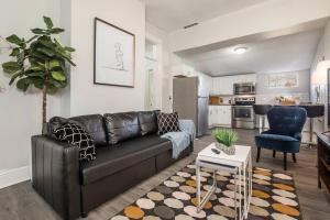 ルイスビルにあるLouisville Dream House 4BR 2BA by CozySuitesのリビングルーム(黒い革張りのソファ付)、キッチン