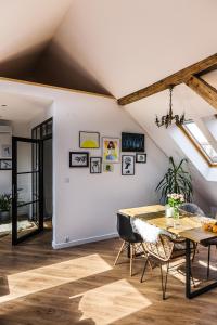 a room with a table and chairs and a ceiling with skylights at Apartament Dobre Miejsce 2 in Ustrzyki Dolne