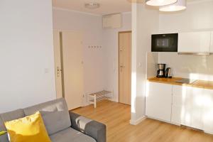 a living room with a couch and a kitchen at Apartament 15 in Świnoujście