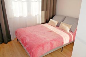 łóżko z różowym kocem i 2 poduszkami w obiekcie Apartament 15 w Świnoujściu