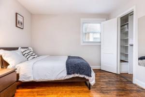 a white bedroom with a bed and a window at Gorgeous Home 10 min to DC by CozySuites in Alexandria