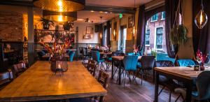 a restaurant with tables and chairs in a room at Hotel Café Restaurant 't Raedhûs in Dokkum