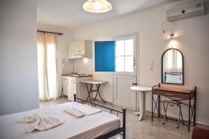 a small room with a bed and a kitchen at Molos Studios in Naxos Chora