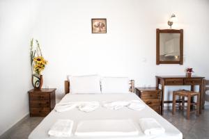 a bedroom with a white bed and a mirror at Molos Studios in Naxos Chora