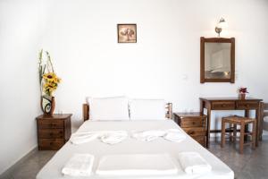 een slaapkamer met een wit bed en een spiegel bij Molos Studios in Naxos Chora
