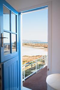 een open deur naar een balkon met uitzicht op het strand bij Molos Studios in Naxos Chora