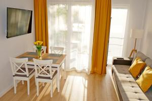 sala de estar con mesa, sillas y sofá en Apartament 15 en Świnoujście