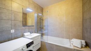 a bathroom with a tub and a sink and a bath tub at Les Freinets - Apt D102 - BO Immobilier -Châtel Multipass 2026 Activités en Été en option à 4euros par jour et par personne in Châtel