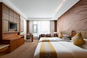 una camera d'albergo con due letti e una televisione di Yun'an Huidu Hotel a Kunming Altre 27 foto