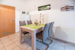 a dining room with a wooden table and chairs at Ferienwohnung Romy in Naumburg
