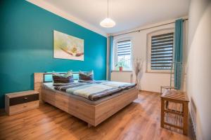 a bedroom with a large bed with blue walls at Ferienwohnung Romy in Naumburg