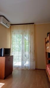 a living room with a large window with curtains at Apartmani Smiljanic app 3 in Soko Banja