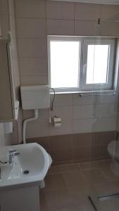 a bathroom with a sink and a toilet and a window at Apartmani Smiljanic app 3 in Soko Banja +16 photos