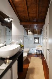 łazienka z dużą białą umywalką i 2 toaletami w obiekcie Hotel Del Porto w mieście Torri del Benaco