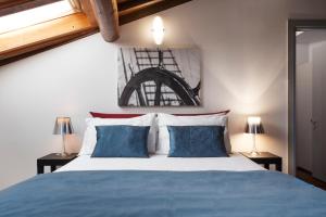 una camera con un letto blu e bianco con due lampade di Hotel Del Porto a Torri del Benaco