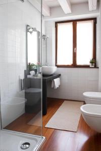 bagno bianco con lavandino e servizi igienici di Hotel Del Porto a Torri del Benaco
