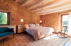 a bedroom with a bed and a brick wall at Casa Anamaria Hotel in Ollers