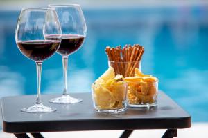 a glass of wine and a plate of food on a table at B&B ARENA SEVILLA in Tomares