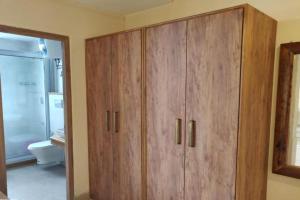 a bathroom with wooden cabinets and a toilet at Azalea in Jajal