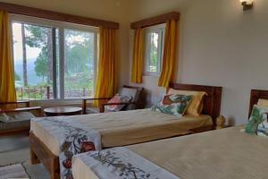a bedroom with two beds and a large window at Azalea in Jajal