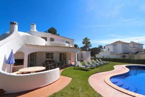 a villa with a swimming pool in front of a house at Vila Girasol, 171 - Clever Details in Vilamoura