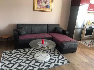 een woonkamer met een bank en een tafel met een rode kaars bij Apartman Petra 2 in Vir