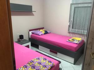 twee bedden in een kamer met roze lakens bij Apartman Petra 2 in Vir