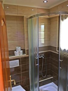 a shower with a glass door in a bathroom at Garni Hotel Boke&scaron;ka Noć in Herceg-Novi