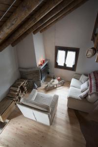 uma sala de estar com dois sofás e uma lareira em Baita Mirellina - Case di Viso em Ponte di Legno