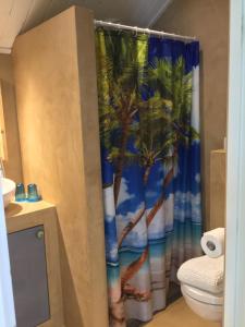 baño con cortina de ducha con palmeras en Beach House Texel, en De Koog 30 fotos más