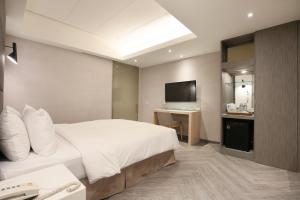 Rúm í herbergi á Dandy Hotel-Daan Park Branch