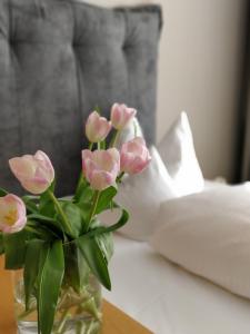 eine Vase voller rosa Blumen auf dem Tisch in der Unterkunft Hotel an der Stadtmauer in Schorndorf