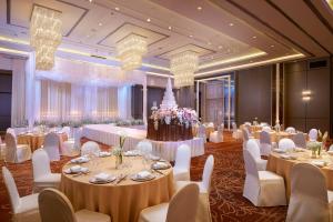 a banquet hall with white tables and chairs and chandeliers at Amari Don Muang Airport Bangkok in Bangkok +37 photos