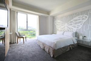 Rúm í herbergi á Dandy Hotel-Daan Park Branch