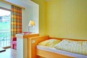 a bedroom with a bed with a lamp and a window at Der Lecher in Lech am Arlberg