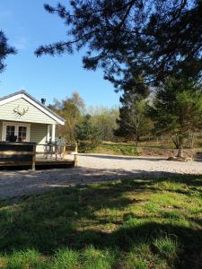 a white house with a porch next to a road at Osprey lodge in Elgin +7 photos