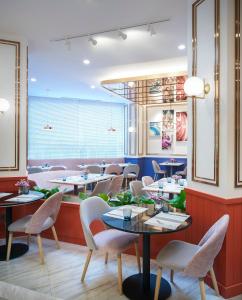 a restaurant with tables and chairs and a large window at Amari Don Muang Airport Bangkok in Bangkok