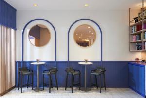 a blue bar with stools and two mirrors at Amari Don Muang Airport Bangkok in Bangkok