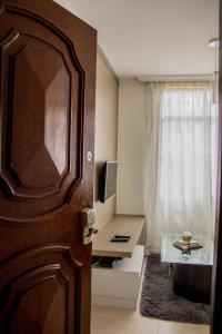 uma porta para um quarto com uma televisão e uma janela em MonteSanto Del Rey em Belo Horizonte