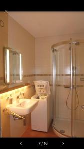 un baño con lavabo y ducha en Ferienwohnung mit Garten und Pool in Ascona, en Ascona 25 fotos más