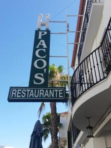 a sign for a restaurant on the side of a building at Hostal Restaurante Pacos in Herrera del Duque