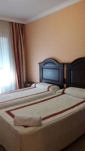 A bed or beds in a room at Hostal Restaurante Pacos