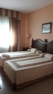A bed or beds in a room at Hostal Restaurante Pacos