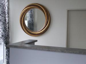 a mirror on a wall next to a shelf at Greyfriars Motel in Greytown