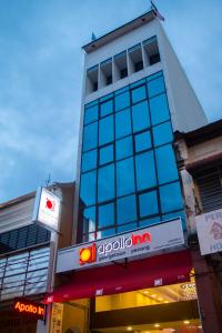 a tall building with a sign on a street at Apollo Inn in George Town