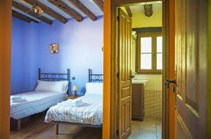 two beds in a room with blue walls and a door at Casa Pirinea Ordesa in Belsierre