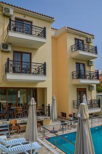 a hotel with a swimming pool and tables and umbrellas at Anthena Studios in Skiathos Town