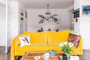 a yellow couch in a living room with a table at Apartament Dobre Miejsce in Ustrzyki Dolne